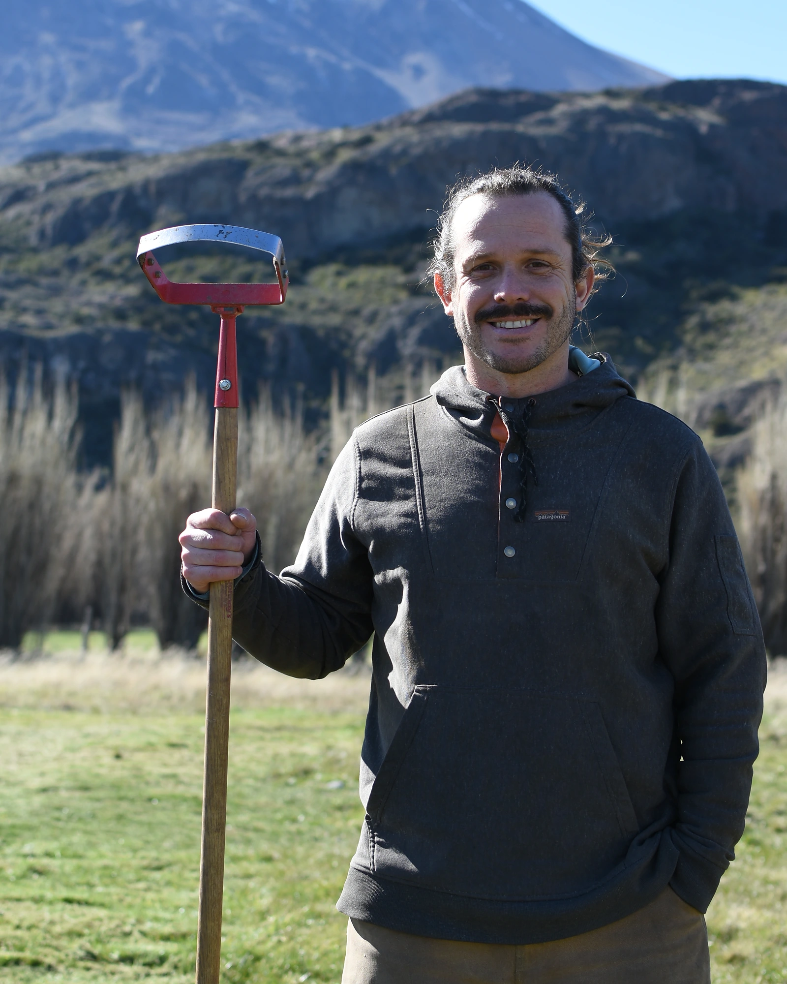 Javier Soler en terreno, con una pala y las montañas de la Patagonia al fondo